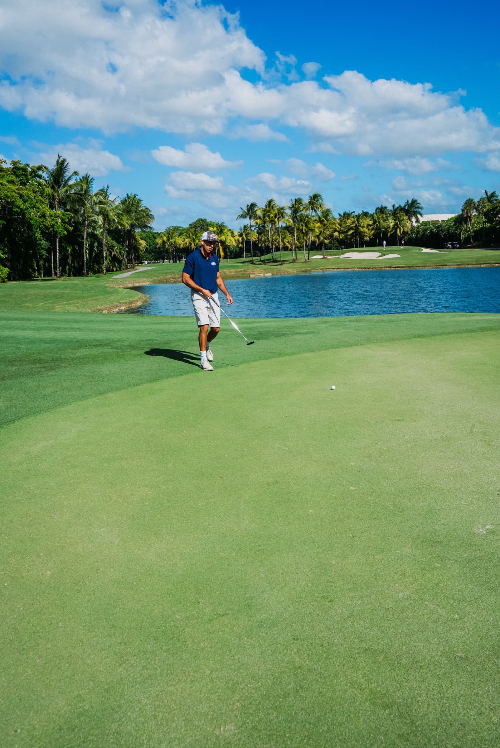 Golfer on a wide fairway under a blue sky