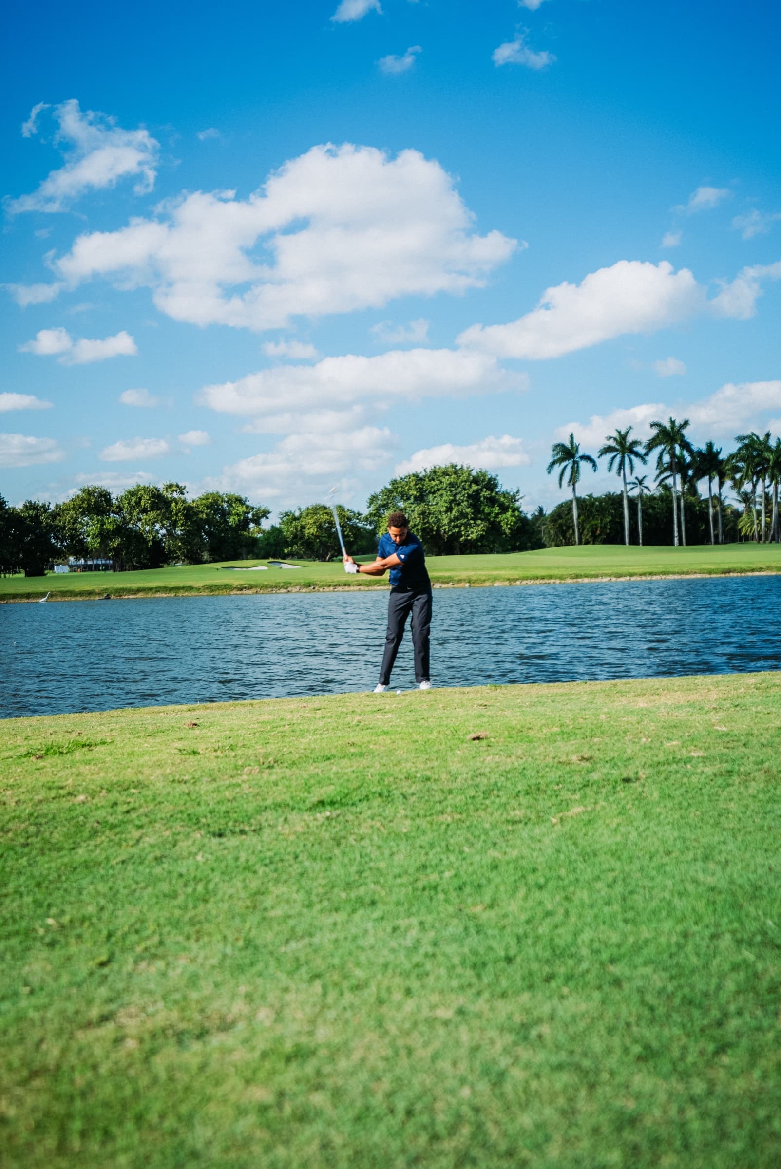 Golfer beside the lake on the course