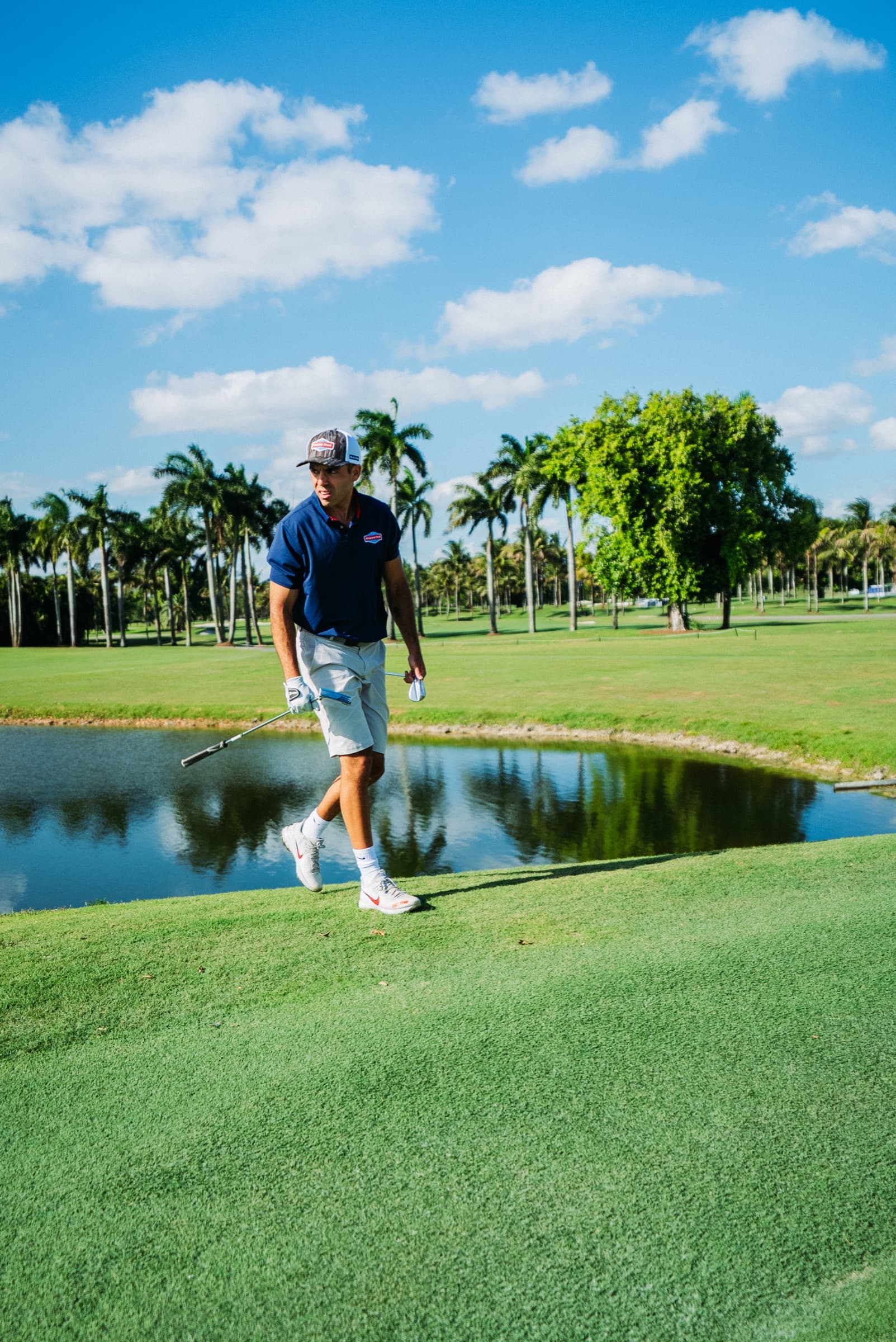 Golfer reflected in a pond on the course