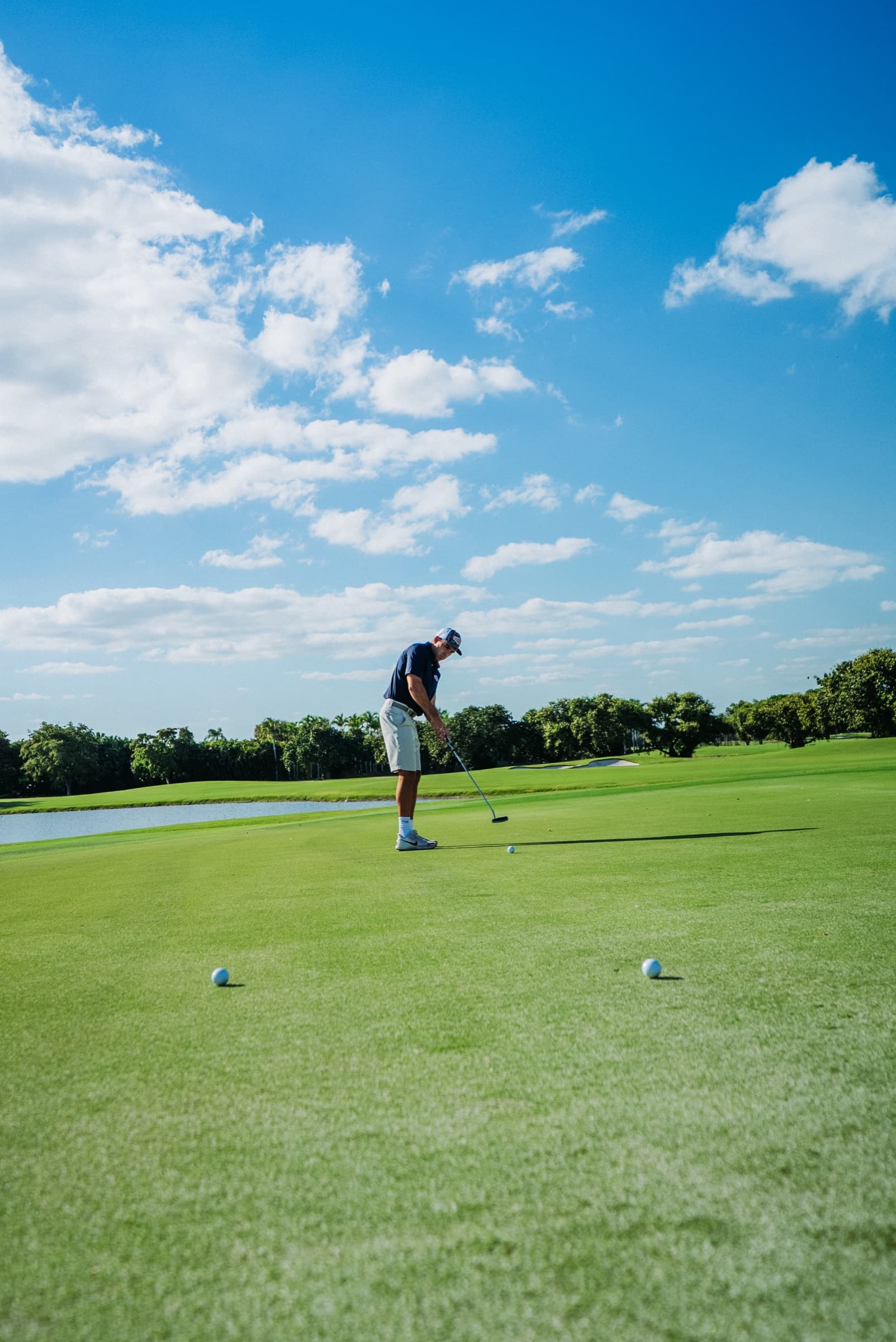 Distant golfer on an open fairway beneath a large sky