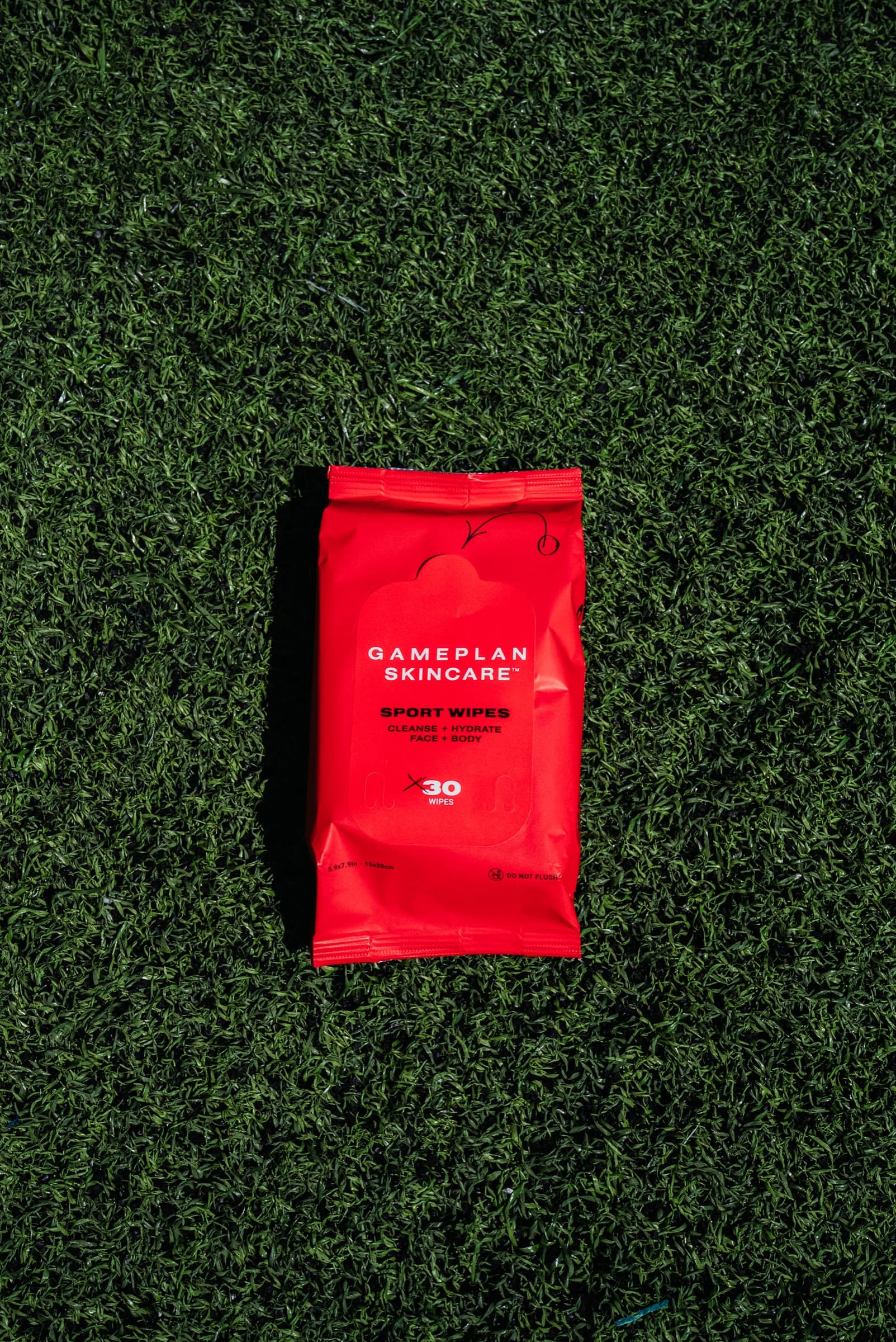 Red product pouch lying on artificial turf